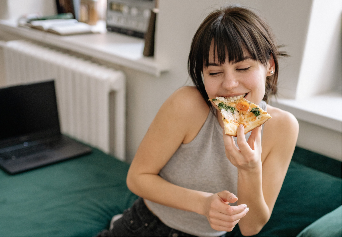 a girl eating a slice of pizza